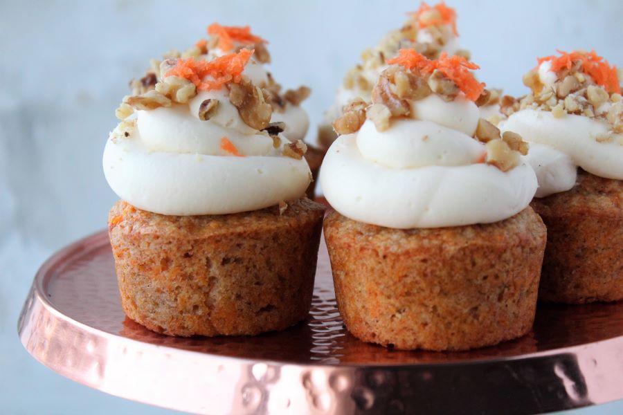 carrot cake cupcakes on cake stand, white wood background