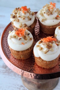 carrot cake cupcakes on cake stand, white wood background