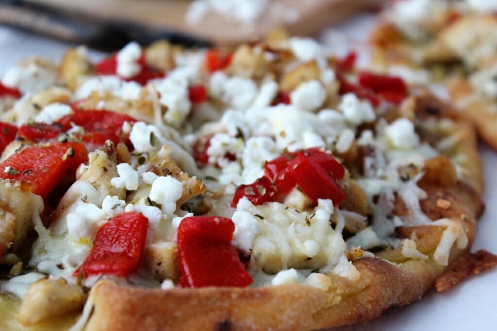 naan bread pizzas with chicken, red peppers, cheese, and herbs